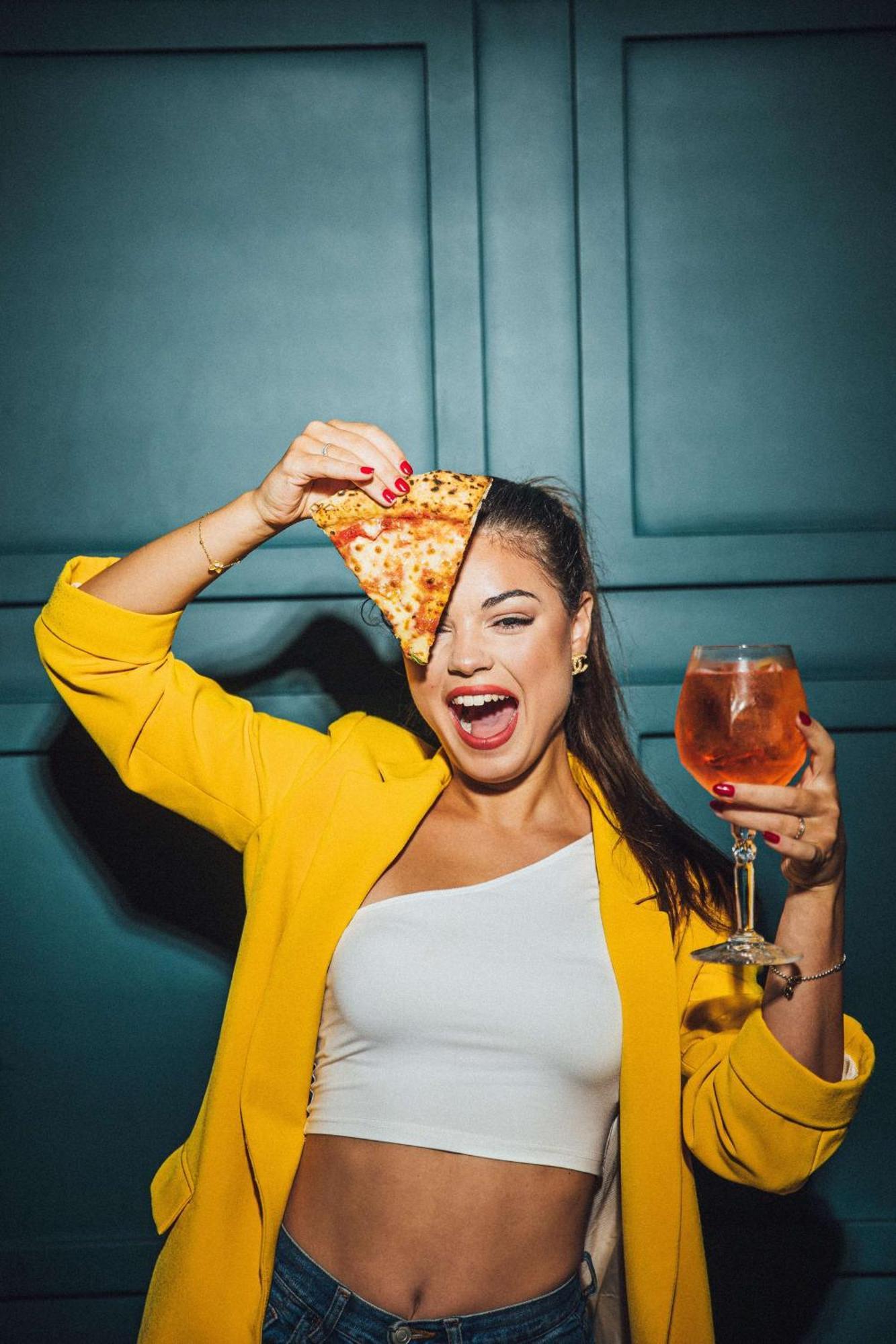 Ja Ocean View Hotel, Jumeirah Beach Dubai Luaran gambar A woman holding a slice of pizza